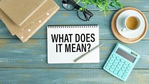 What Does It Means text on a card on a wooden background next to a pen, cal.. Stock Photos