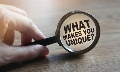 What makes you unique question under magnifying glass. Career business concep 库存照片