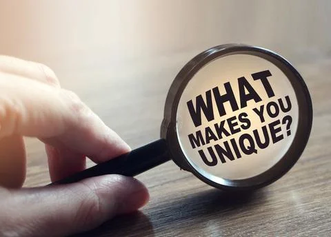 What makes you unique question under magnifying glass. Career business concep 库存照片