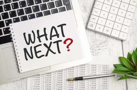 WHAT NEXT text on notepad and laptop on wooden background Stock Photos