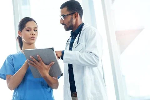 What options do we have available. two young doctors using a digital tablet in a Stock Photos