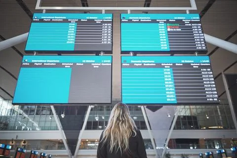 What time is my connecting flight. a woman checking the time of her flight at Stock Photos