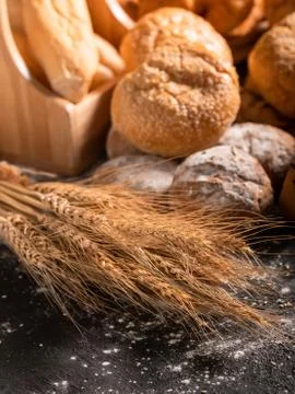 Wheat and group bread on the black wooden table Stock Photos
