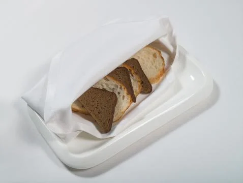 Wheat and rye bread on a plate on a white background Stock Photos