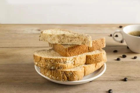Wheat bread with coffee beans and coffee cup on wooden table Fotos Stock