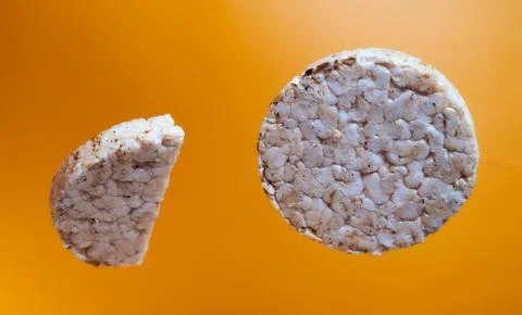 Wheat breads fall on orange background. Advertising photo. Close-up Stock Photos
