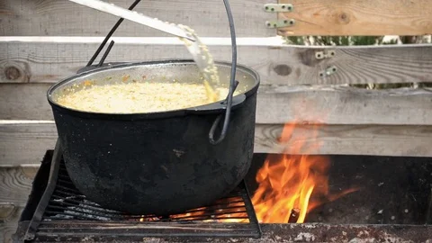 Wheat cereal with meat is prepared on grill, it is stirred with spoon, closeup Stock Footage 112433916