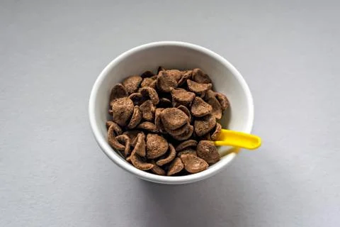 Wheat &amp; chocolate based cereal flakes in a white bowl with yello Stock Photos