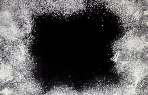 Wheat flour on a black table. Abstract background. Stock Photos