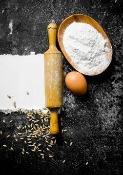 Wheat flour with egg, rolling pin and grain. Foto stock