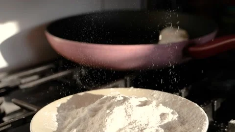 Wheat flour is falls into plate in kitchen, cooking concept slow motion Vidéo 146815714