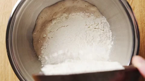 Wheat flour falls into yeast mixture for bread dough Stock Footage 341429467