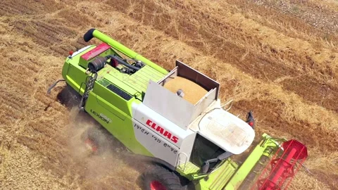 Wheat grain picker harvester processing a large field, Aerial follow view. Stock Footage 131430487
