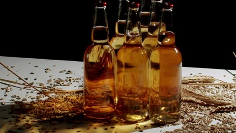 Wheat grains slowly falling on beer bottles Stock Footage 342737788