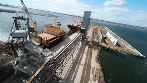Wheat loading to bulk carrier ship from birds eye view by fpv drone Stock Footage 304562494