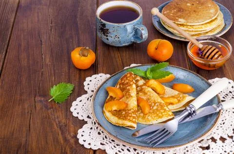 Wheat pancakes with honey and apricots. Photo Stock Photos