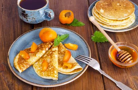 Wheat pancakes with honey and apricots. Photo Stock Photos