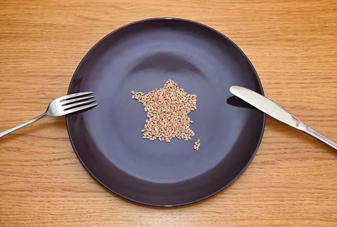 Wheat on a plate laid out in the shape of a map of France. Food concept Stock Photos