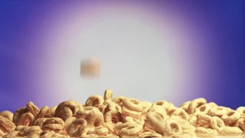 Wheat Rings falling on heap on purple background Stock Footage