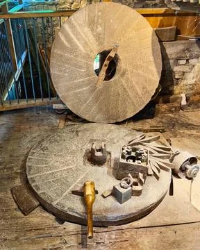 Wheat stone Grinder wheel, at an old town mill under surrounded by antique .. Stock Photos