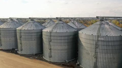 Wheat storage elevator. silver silos on agro manufacturing plant for processing Stock Photos