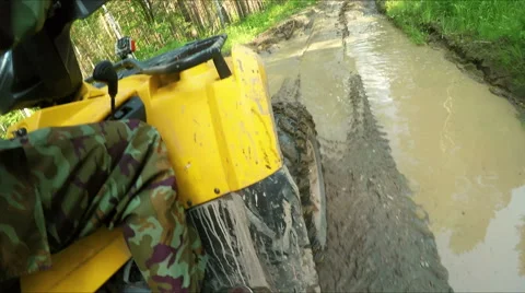 Wheel ATV drives into a deep mud puddle Stock Footage 57707616