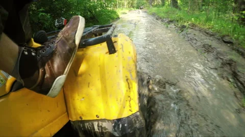Wheel ATV drives into a deep mud puddle Stock Footage 57708109