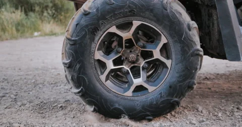 Wheel of ATV starting to spin and kicking up ground or dirt. Quad begin the move Stock Footage 159178919