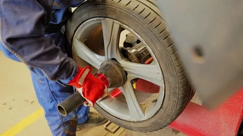 Wheel Balancing Service in Auto Workshop - Mechanic Secures Alloy Rim on Machine Stock Footage 342781030