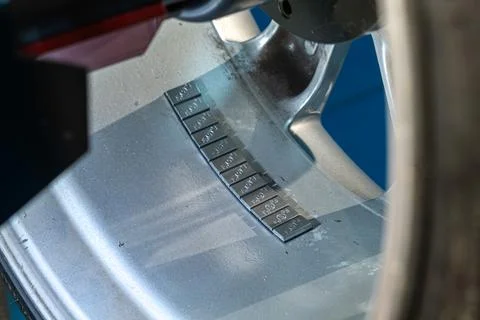 Wheel balancing weights attached to the inner side of a silver alloy rim in.. 写真素材
