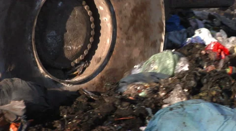 Wheel of a bulldozer driving through the unsorted trash on a landfill site. 動画素材 61758089