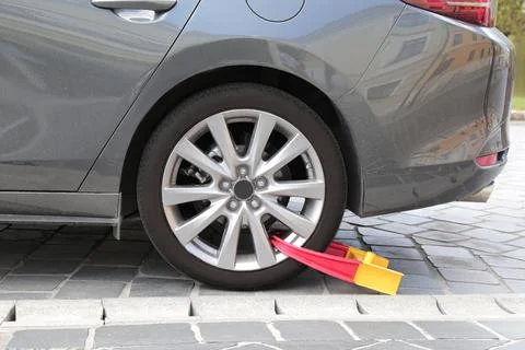 The wheel of the car is blocked for violating the rules. punishment. police. Stock Photos