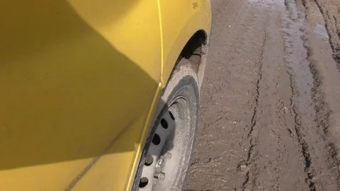 A wheel of a car driving through mud slides in a puddle on the road. Stock Footage 117367540