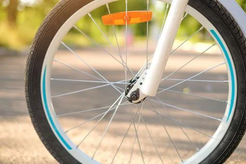 The wheel of a children's bicycle in the rays of the setting sun. Foto stock