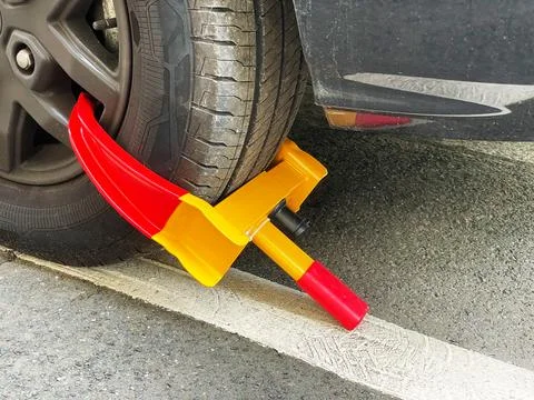 Wheel clamp or lock blocking car tire on the street Stock Photos