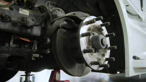 Wheel hub on the track, Various devices and semi truck in a repair shop. Close Stock Footage 297022875