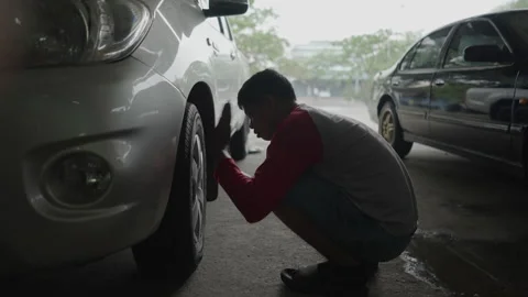 A wheel hubcap is tightened by a Thai man Stock Footage 265065341