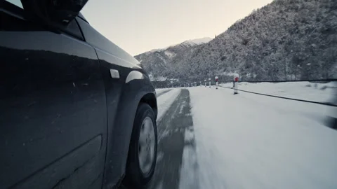 Wheel-Level Shot of a Car Speeding Through a Snowy Mountain Road 库存影片 302219373