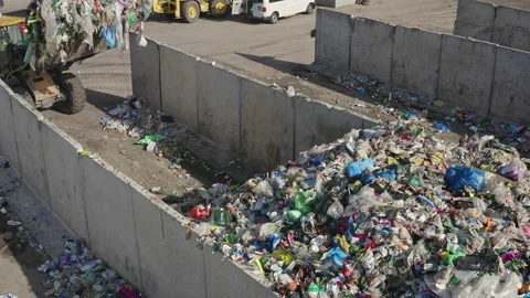 Wheel loader carrying and dumping waste at a recycling center, aerial view Video stock 234213210