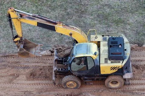 A wheel loader digs the ground at a construction site to pave a road Stock Photos