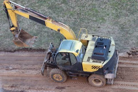 A wheel loader digs the ground at a construction site to pave a road Stock Photos