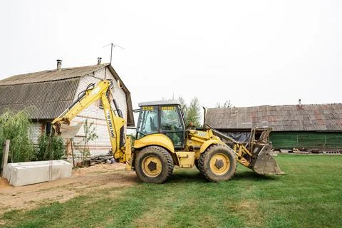Wheel loader. Excavator install the foundation blocks into a trench. Retainin Foto stock