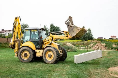 Wheel loader. Excavator install the foundation blocks into a trench. Retainin 스톡 사진