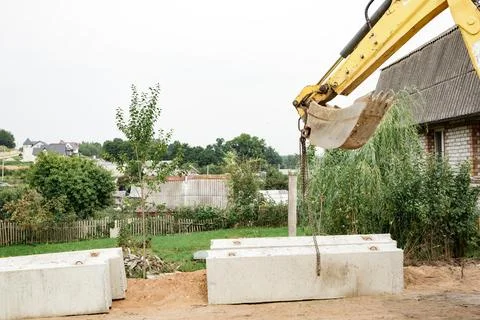Wheel loader. Excavator install the foundation blocks into a trench. Retain.. Foto stock