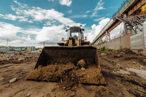 Wheel loader with a full bucket of soil. Production of earthworks Stock Photos