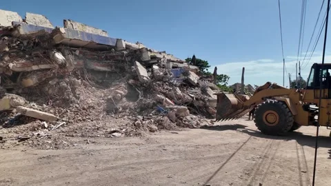 Wheel loader heavy machinery clearing concrete rubble and debris at earthquake Stock Footage 341431778