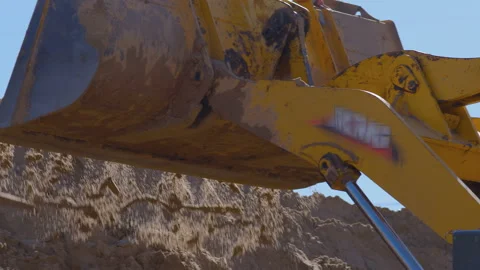 Wheel loader, with its large bucket in front, moves large amounts of land  Stock Footage 147633149