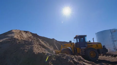 Wheel loader, with its large bucket in front, moves large amounts of land  Stock Footage 161955216