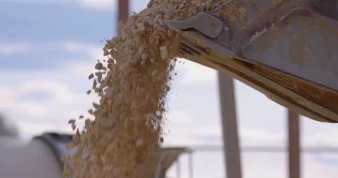 Wheel loader, with its large bucket in front, moves large amounts of gravel  Stock Footage 161959393