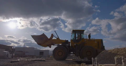 Wheel loader, with its large bucket in front, moves large amounts of gravel  Video stock 161959873